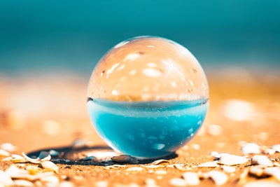 Brown transparent glass ball on the sand
